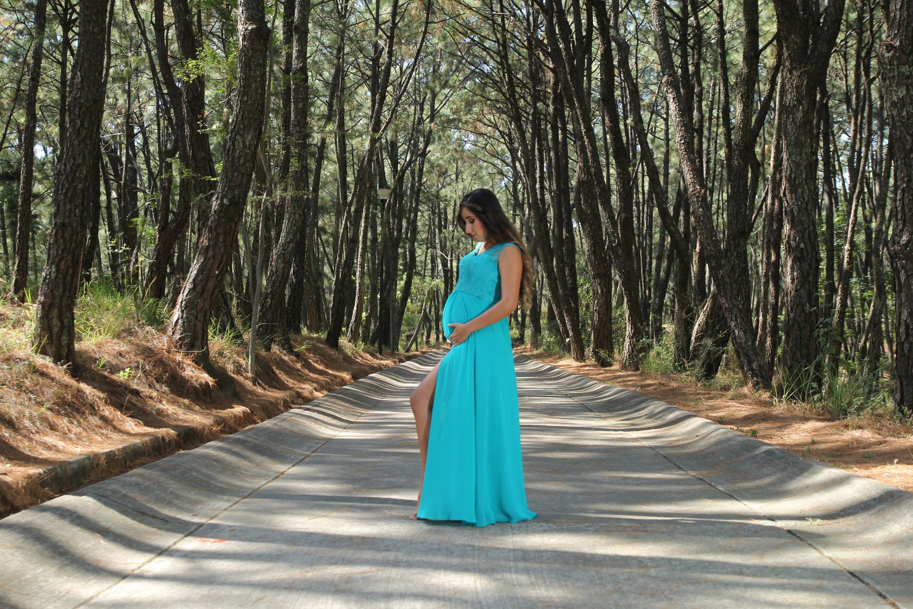 A pregnant woman sipping water while walking in a sunny park, illustrating gentle activity after a membrane sweep, warm natural light, soft focus background, photorealistic
