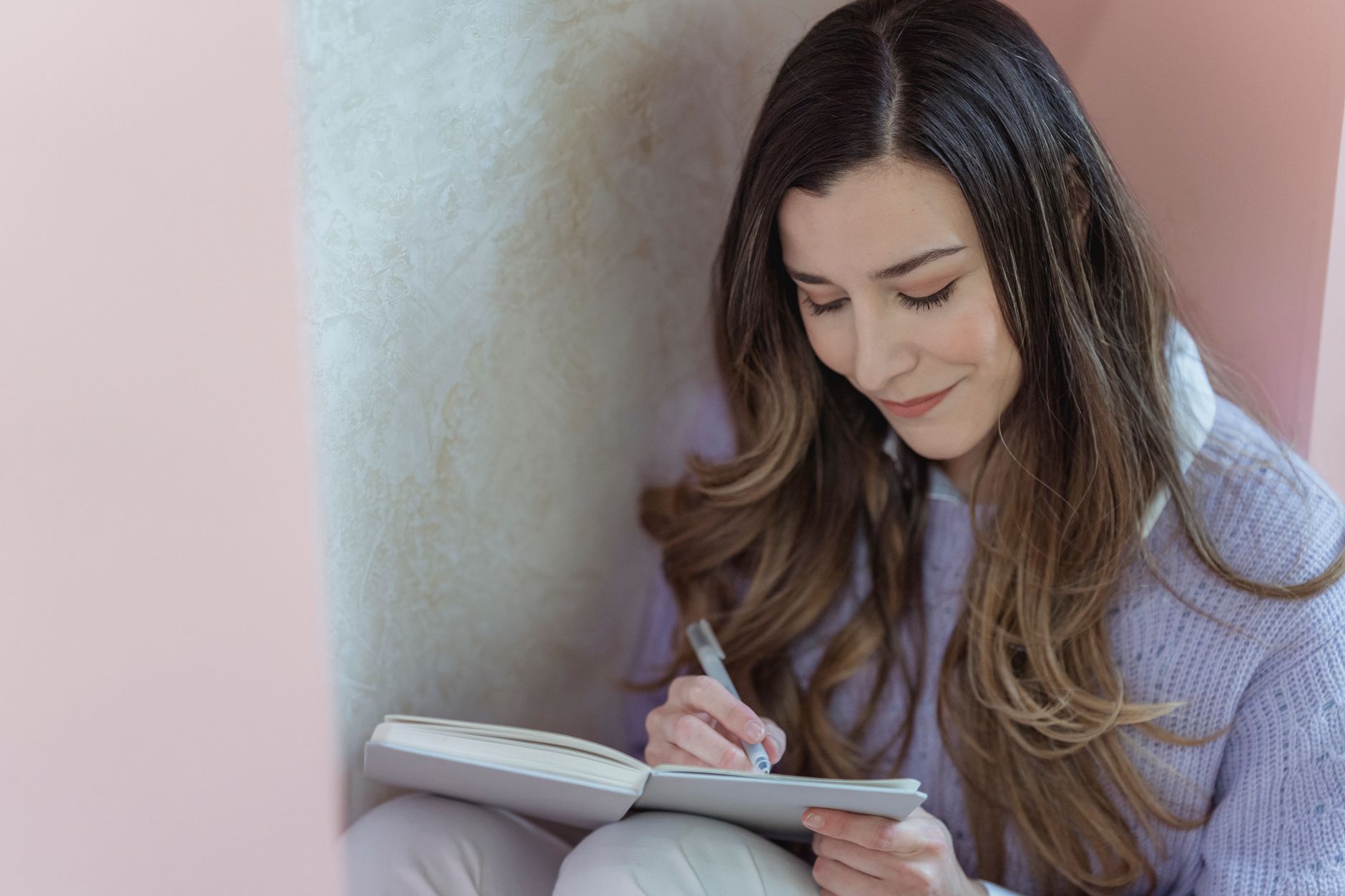 A thoughtful mom writing in a journal or notebook.