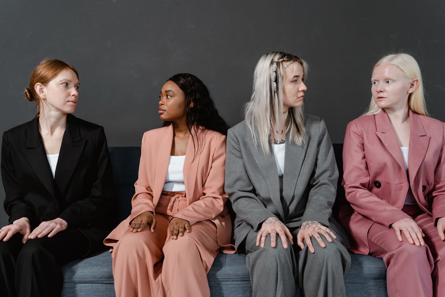 A group of diverse women gathered, laughing and supporting each other, symbolizing a strong support system for mothers.