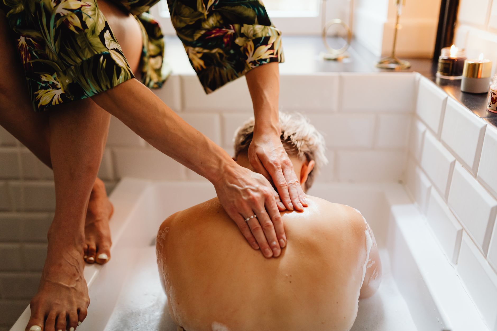 A luxury pregnancy pampering spread: a spa bath, a massage, and a custom jewelry piece.