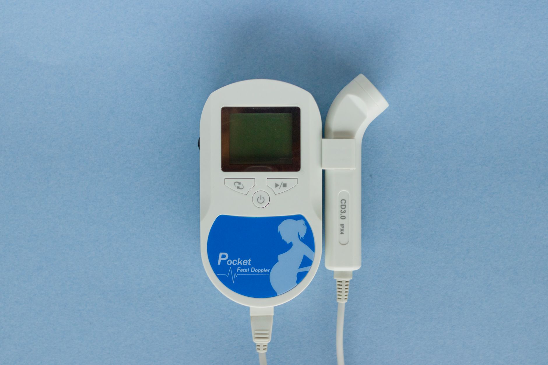 Close‑up of a pregnant belly with two fetal heart rate monitors side by side, illustrating twin monitoring