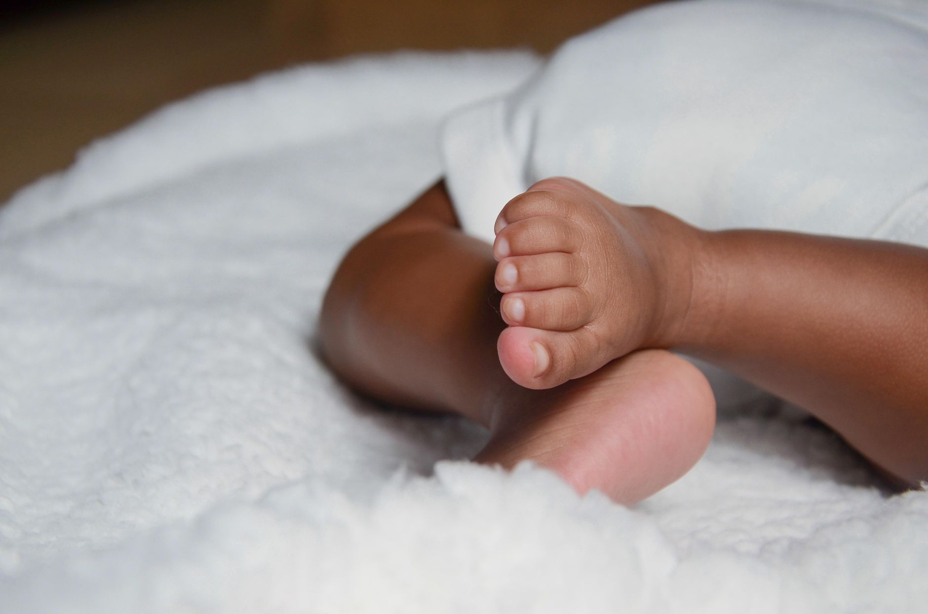 A small bottle of pediatric‑approved gripe water beside a baby’s soft blanket, showing a safe home remedy option