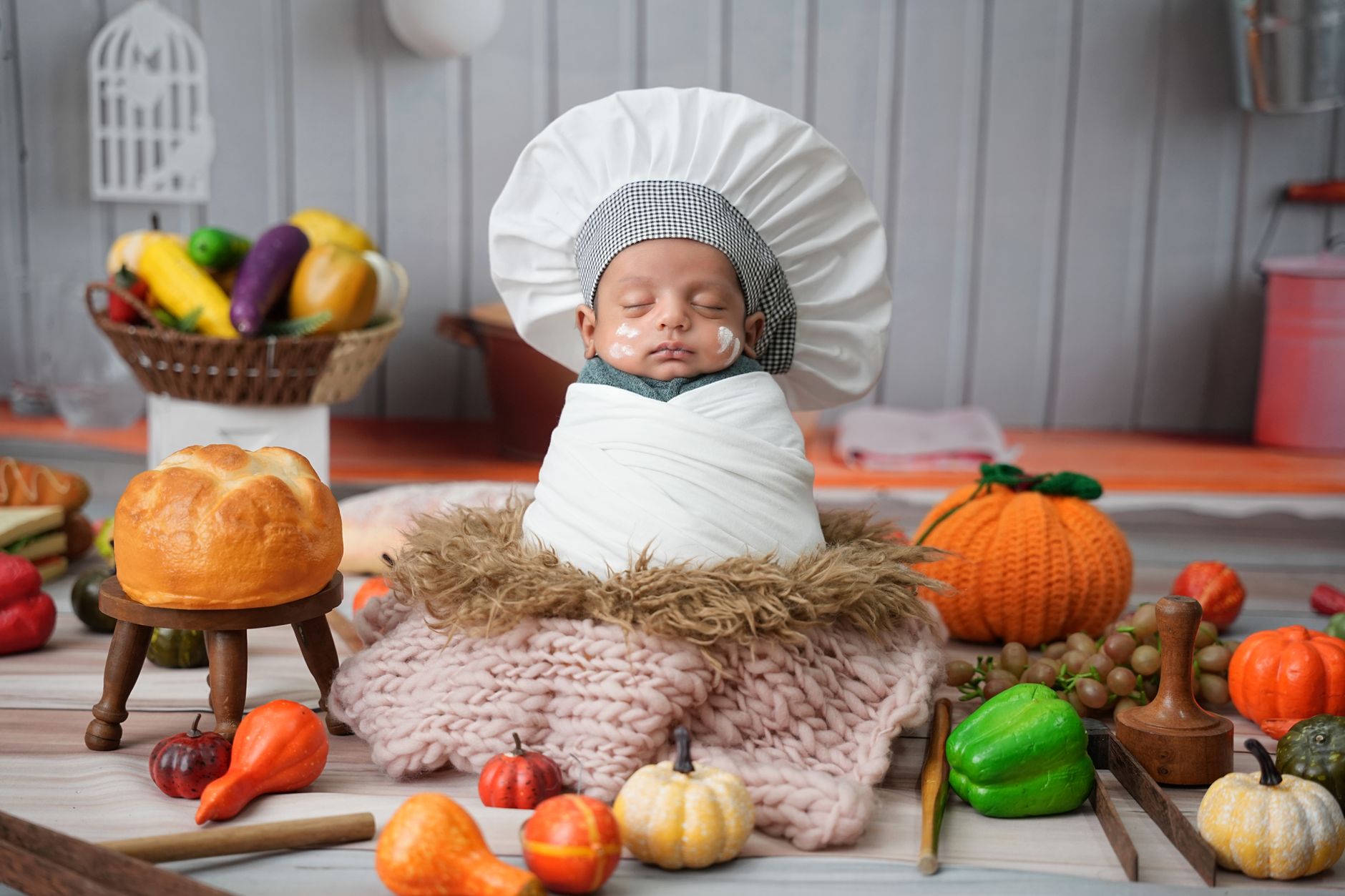 A serene newborn photography setup with a sleeping baby wrapped in a soft blanket, dim lighting, and a photographer capturing the golden hour