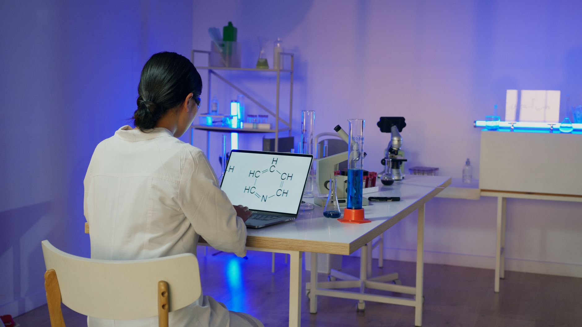 A researcher reviewing a laptop screen displaying a heat map of facial expressions on a newborn, with a soft-lit lab background
