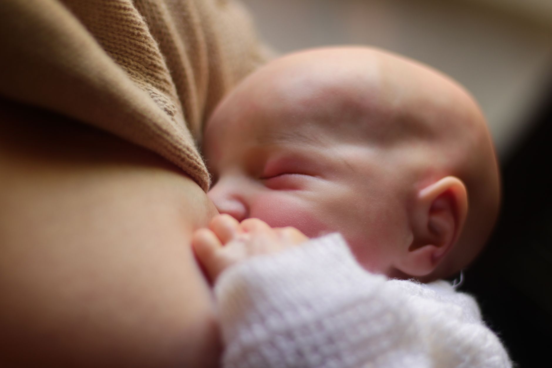 A mother gently holding her newborn baby in a quiet, intimate moment, emphasizing the importance of uninterrupted bonding time.