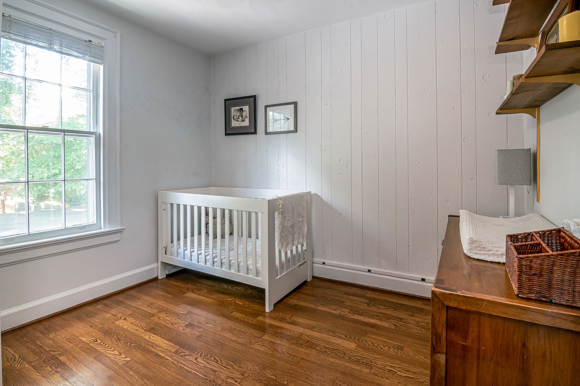 Small nursery organization with wall-mounted storage and convertible crib