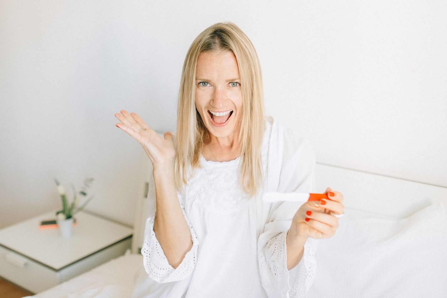 A woman using an ovulation predictor kit, with a positive result