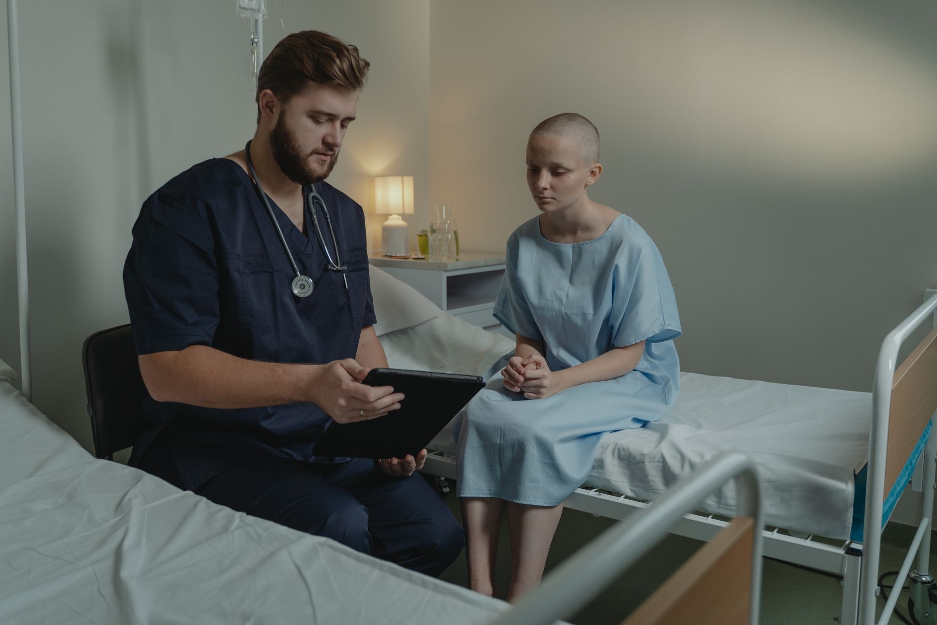 A pediatric nurse using a tablet to record FLACC scores for a toddler after surgery, soft hospital lighting, calm atmosphere