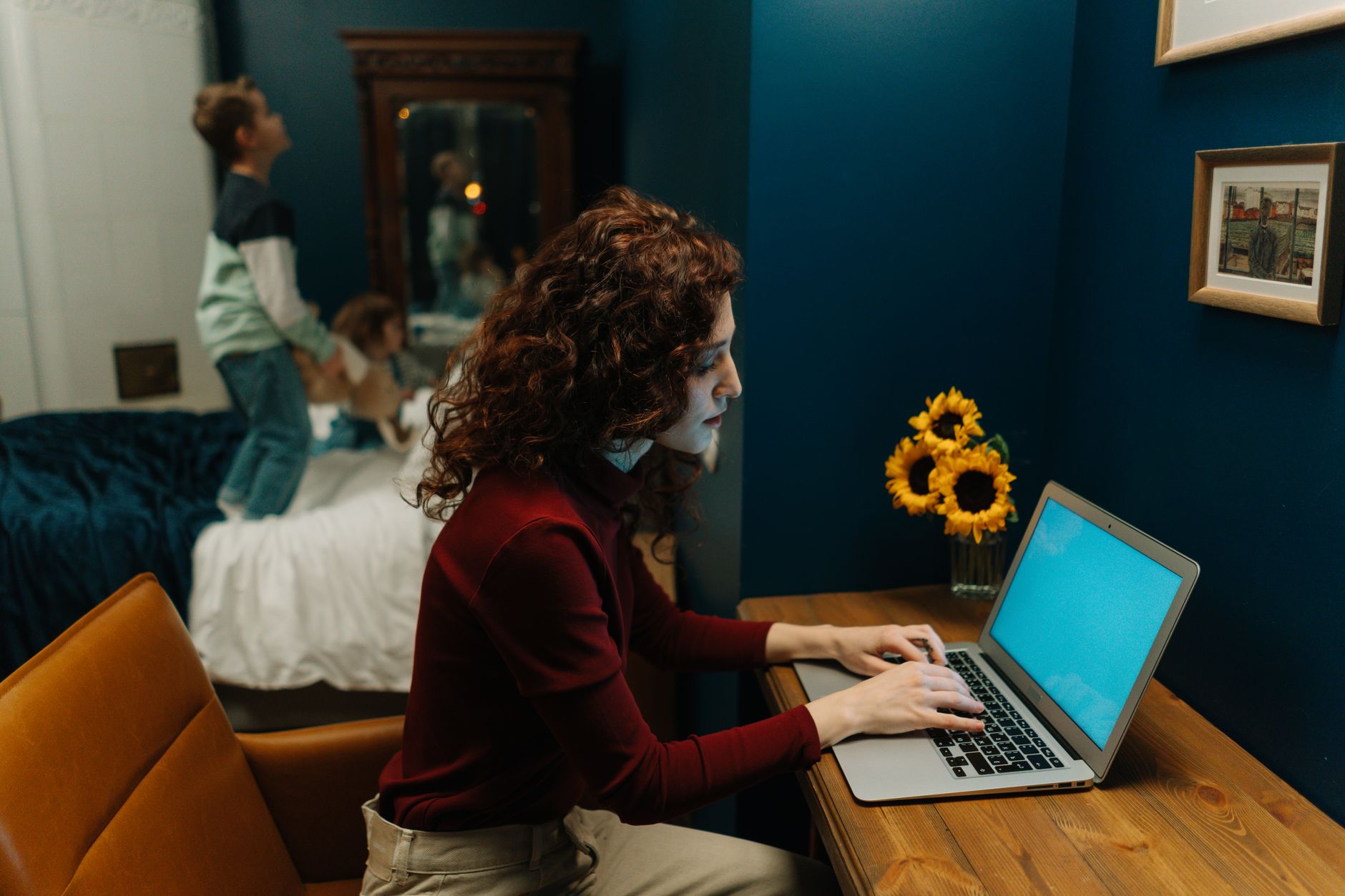 A mother on a laptop conducting a telehealth visit with a pediatrician, soft indoor lighting, living room setting, photorealistic high detail