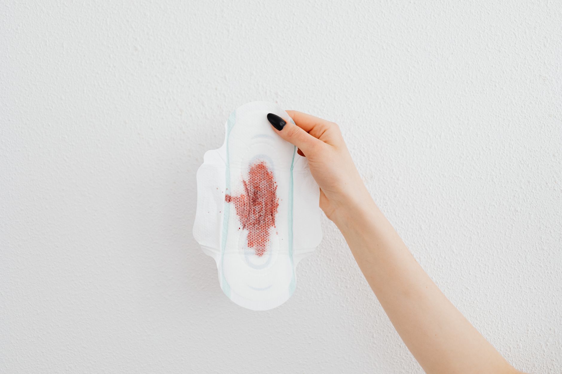 Side-by-side comparison of a calibrated blood-collection drape with marked milliliters and a nurse’s hand estimating blood loss from soaked pads