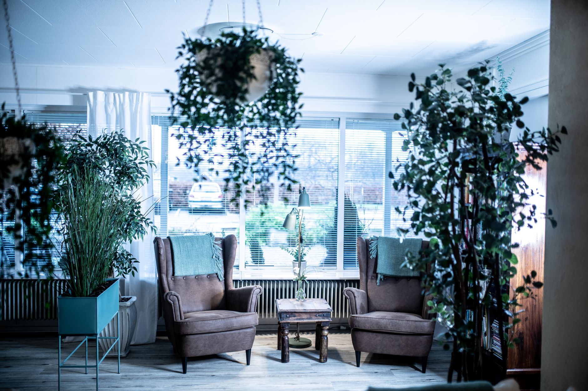 A calm therapy room with a pelvic‑floor trainer device on a table, soft natural light, a plant, and a comfortable chair for a new mother