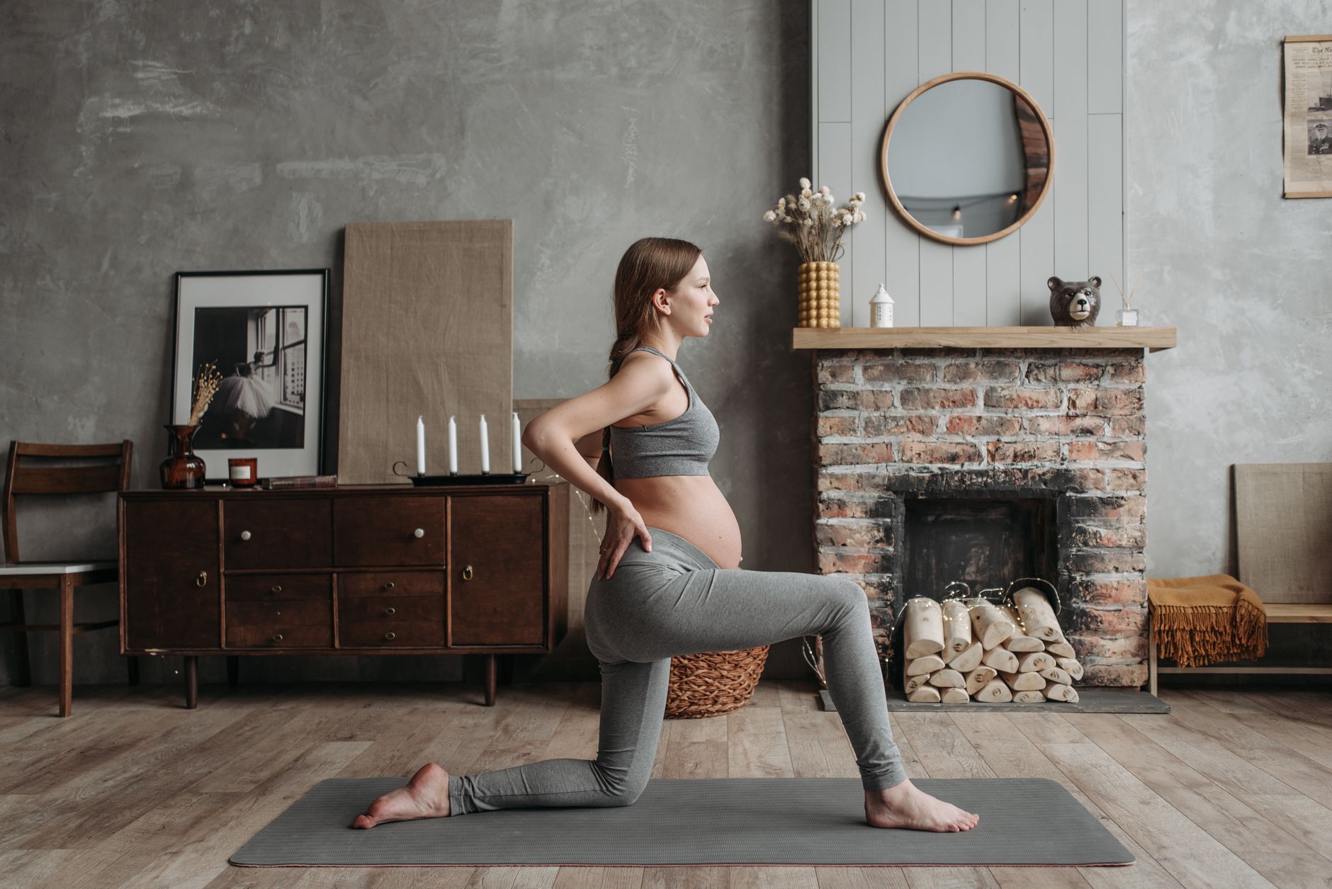 Pregnant woman doing gentle yoga on a sunlit floor, with a yoga block and a soft blanket, serene atmosphere