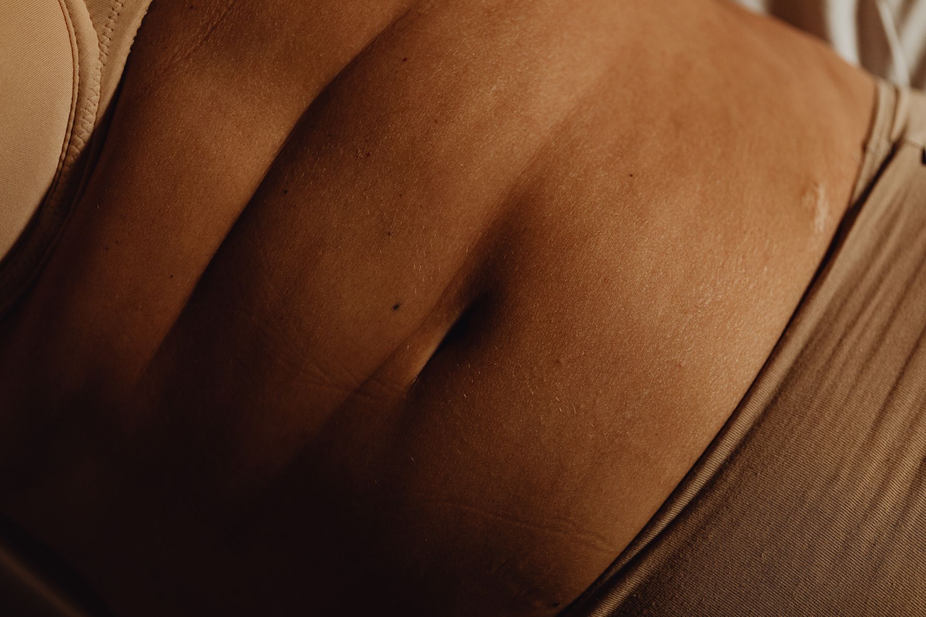 Close‑up of a pregnant belly with a soft blanket, a stethoscope lying nearby, and a digital thermometer beside a cup of tea on a bedside table