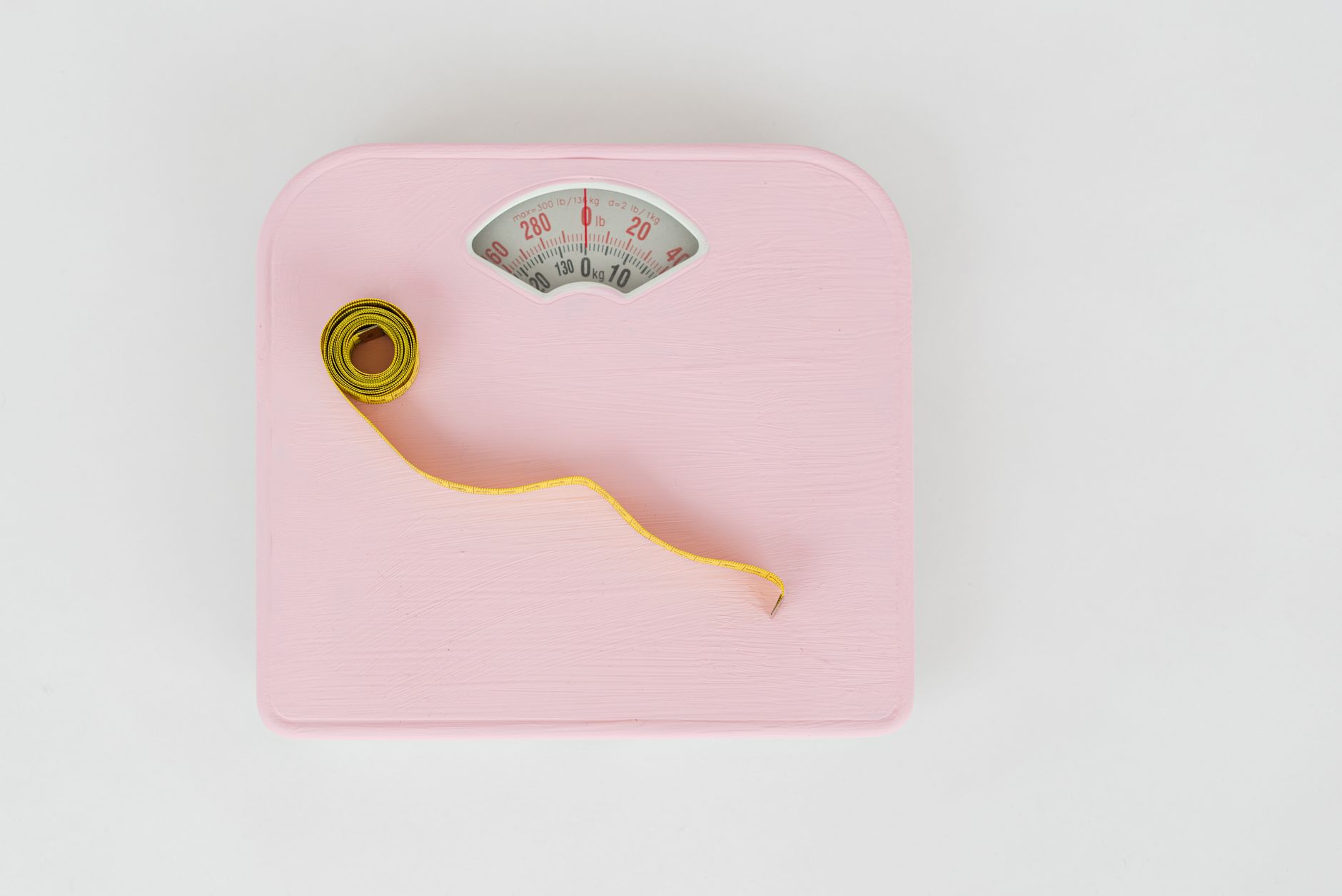 A cozy nursery corner with a wooden tray holding a baby scale, a measuring tape, and a printed Fenton chart, warm morning light