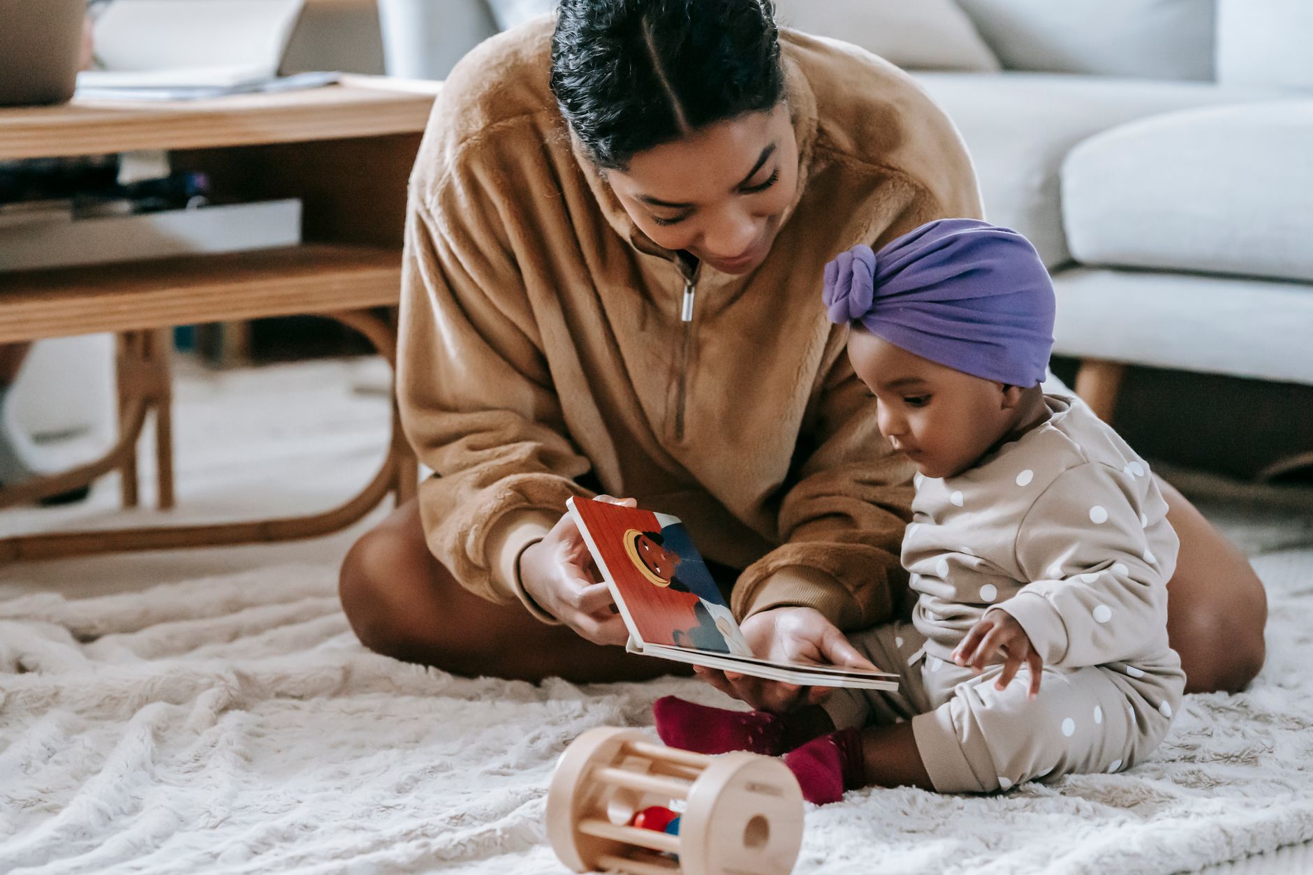 Toddler hugging pregnant mom with baby book
