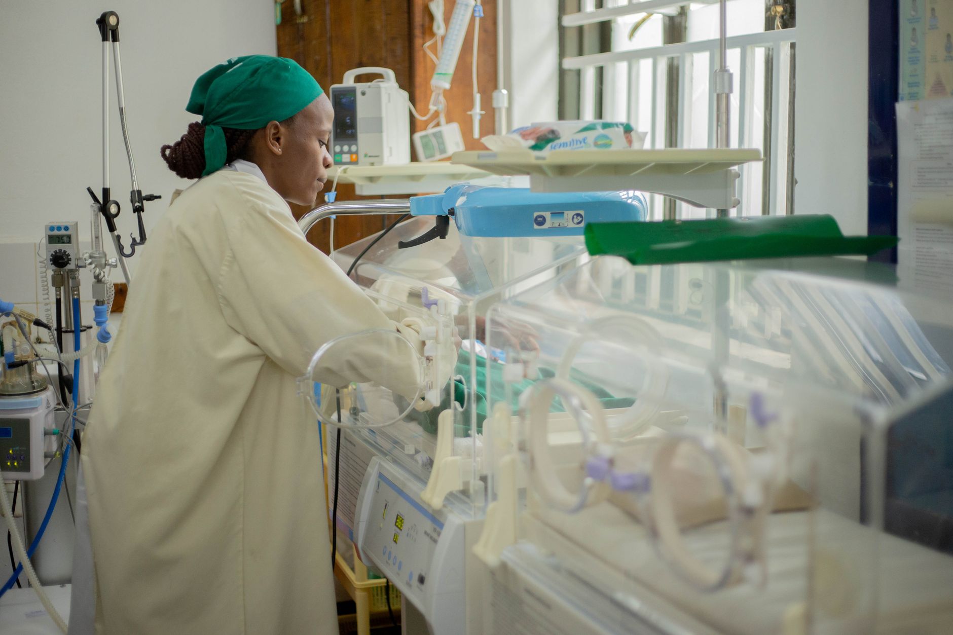 Neonatal clinician using portable lung ultrasound on a preterm infant, gentle hand placement, bright clinical lighting, modern equipment