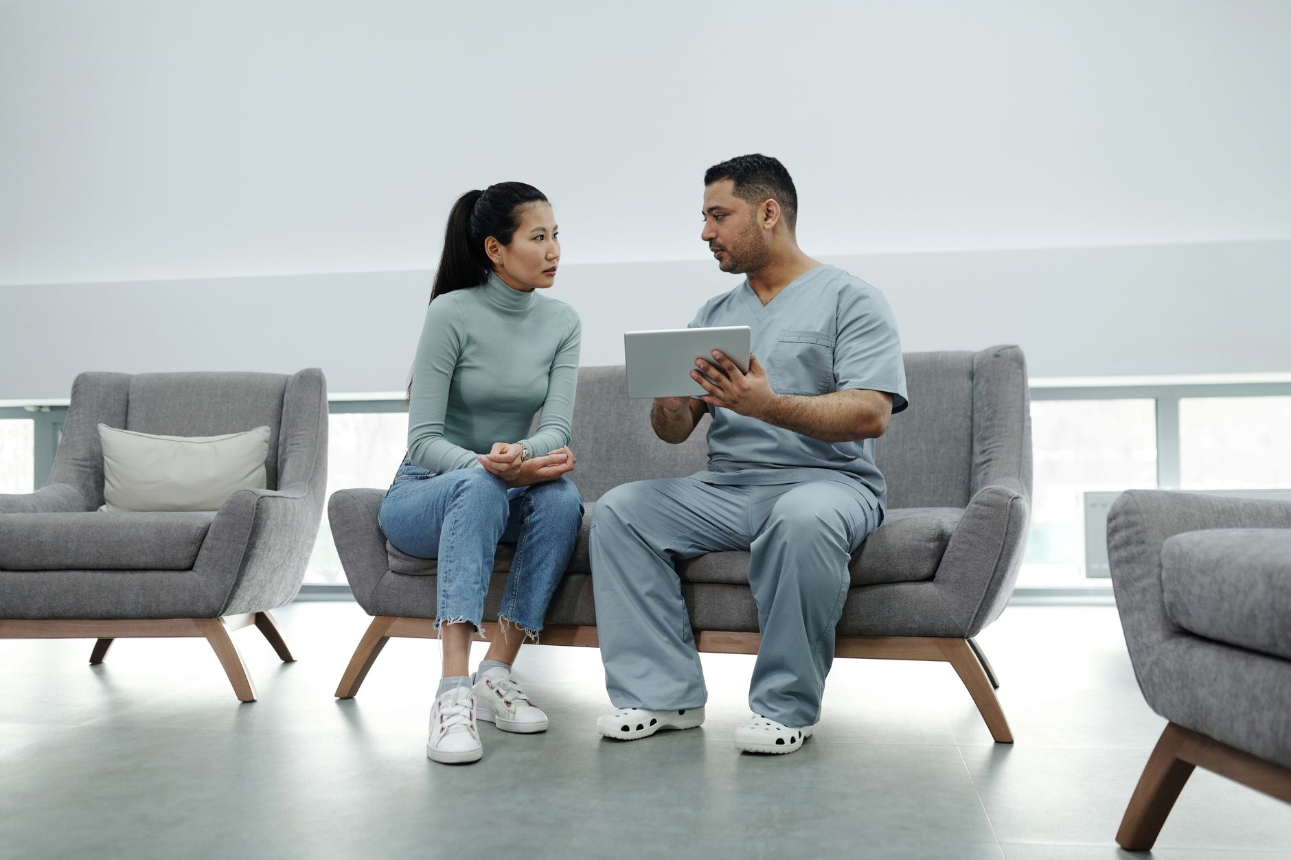 A doctor talking calmly with a pregnant woman in a clinic setting, discussing lab results