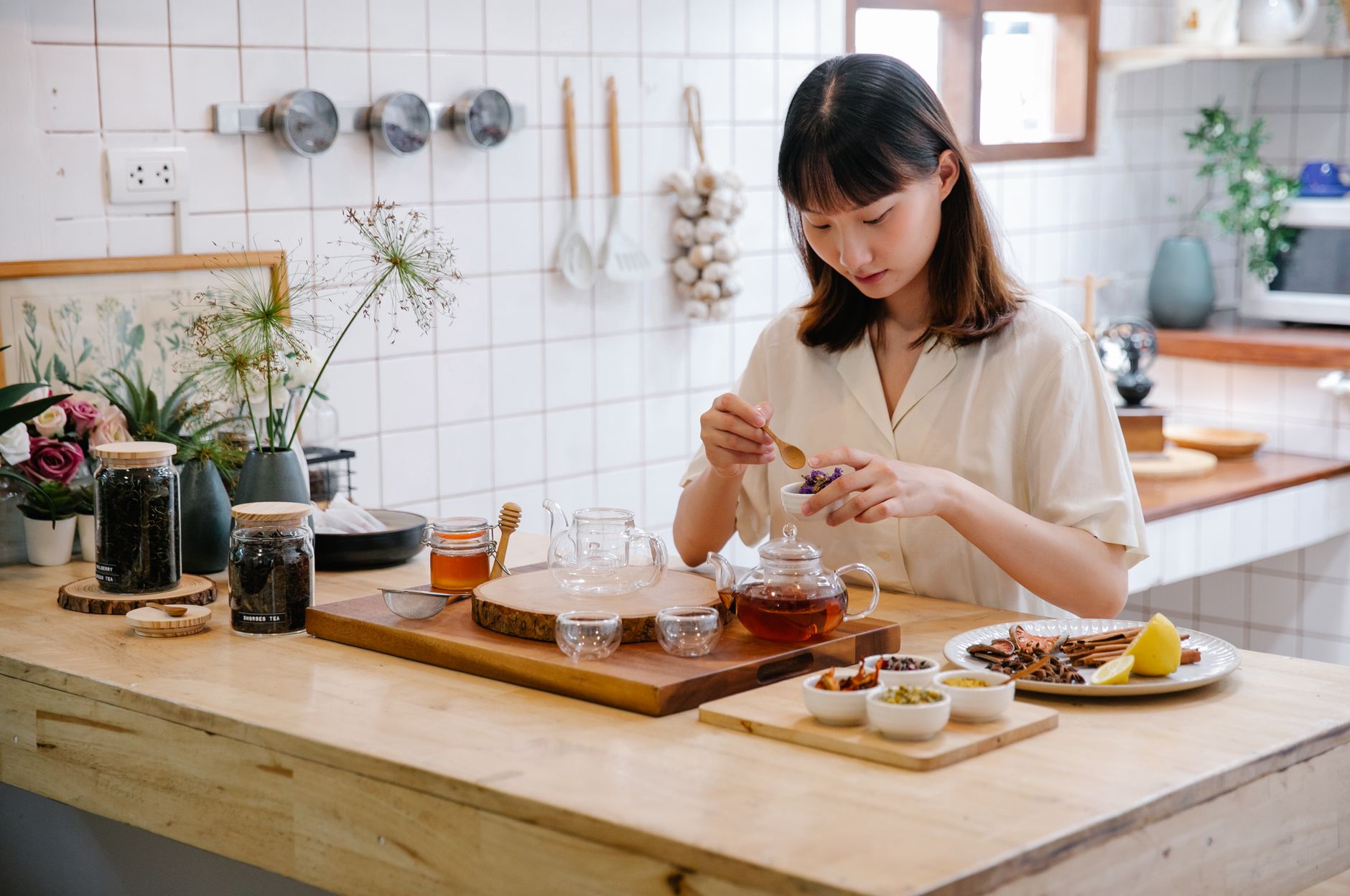a close‑up of a bottle of liquid cough syrup beside a cup of herbal tea and a small jar of honey, illustrating a mix of medicinal and natural cold remedies for a pregnant person