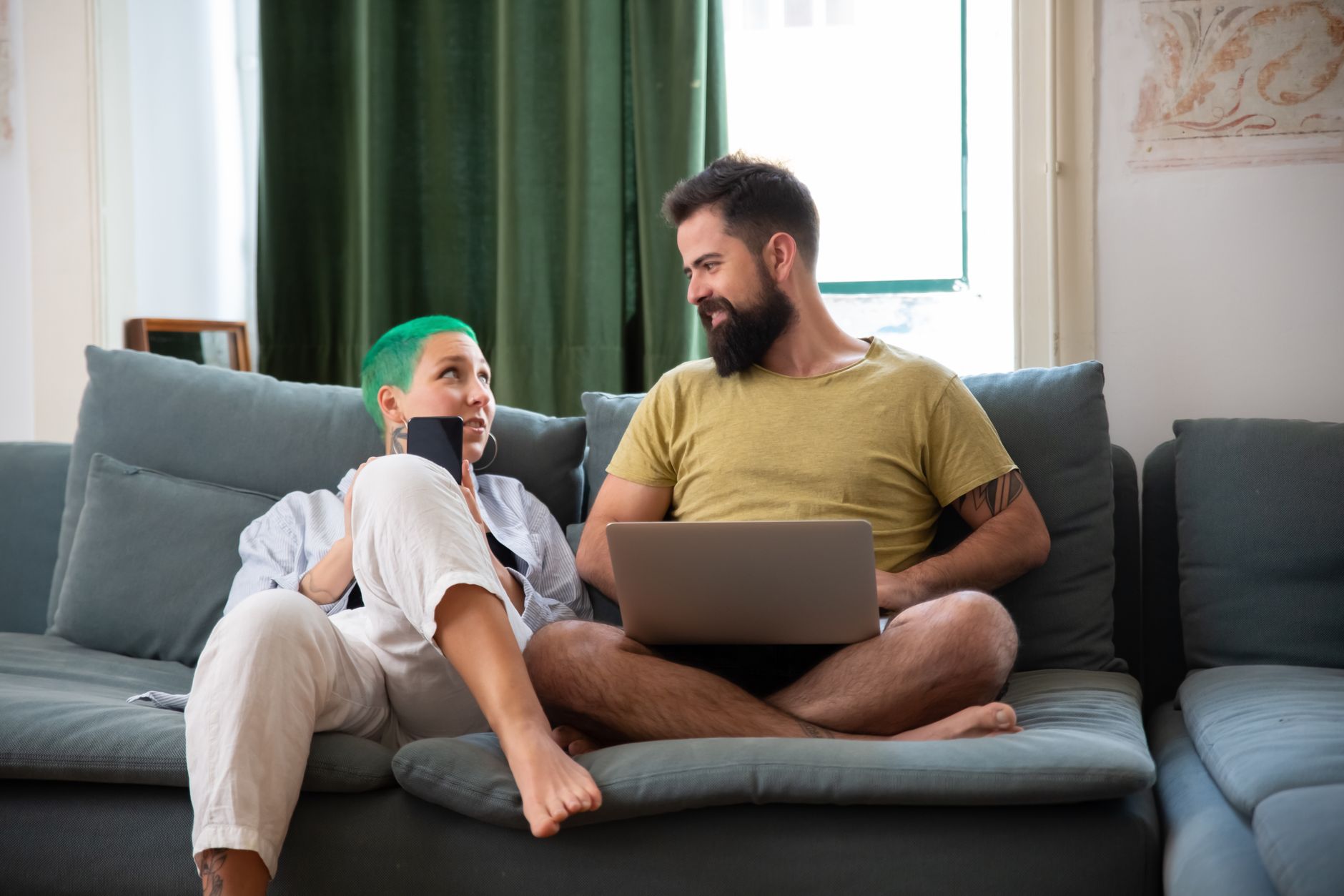 A couple sitting on a couch, looking tired but connected