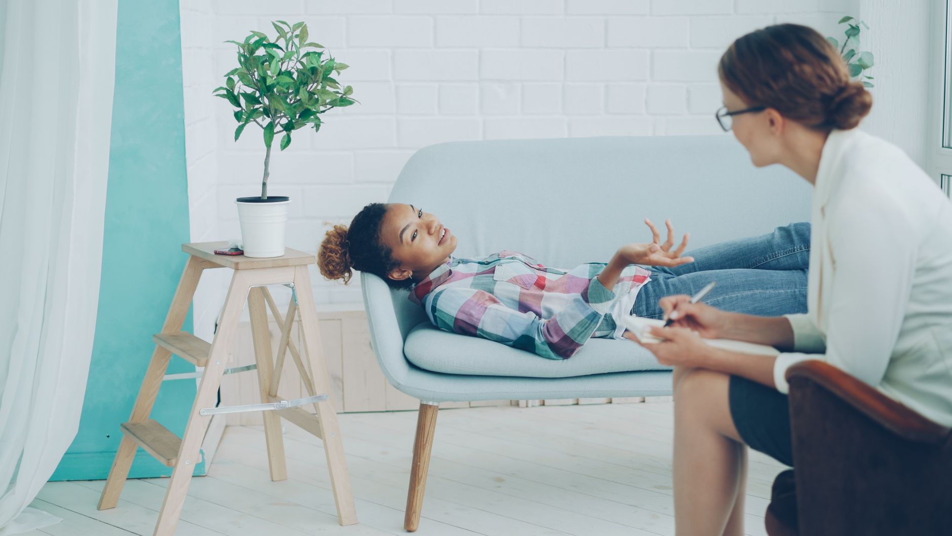 A woman sitting on a couch in a therapist's office.