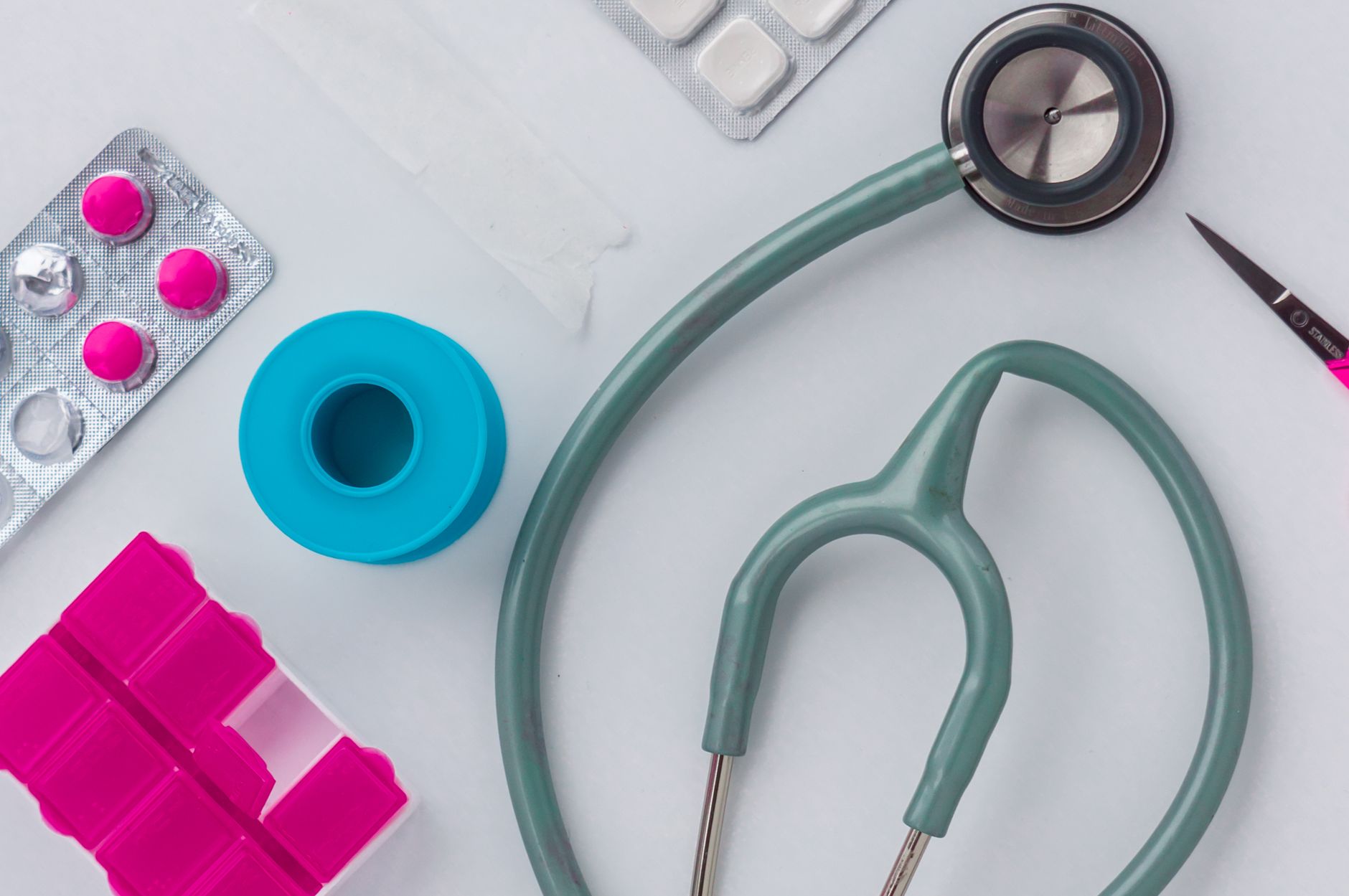 A bedside tray with a tablet displaying the sepsis calculator, a stethoscope, a bottle of saline, and a soft pastel newborn blanket, illuminated by warm natural light