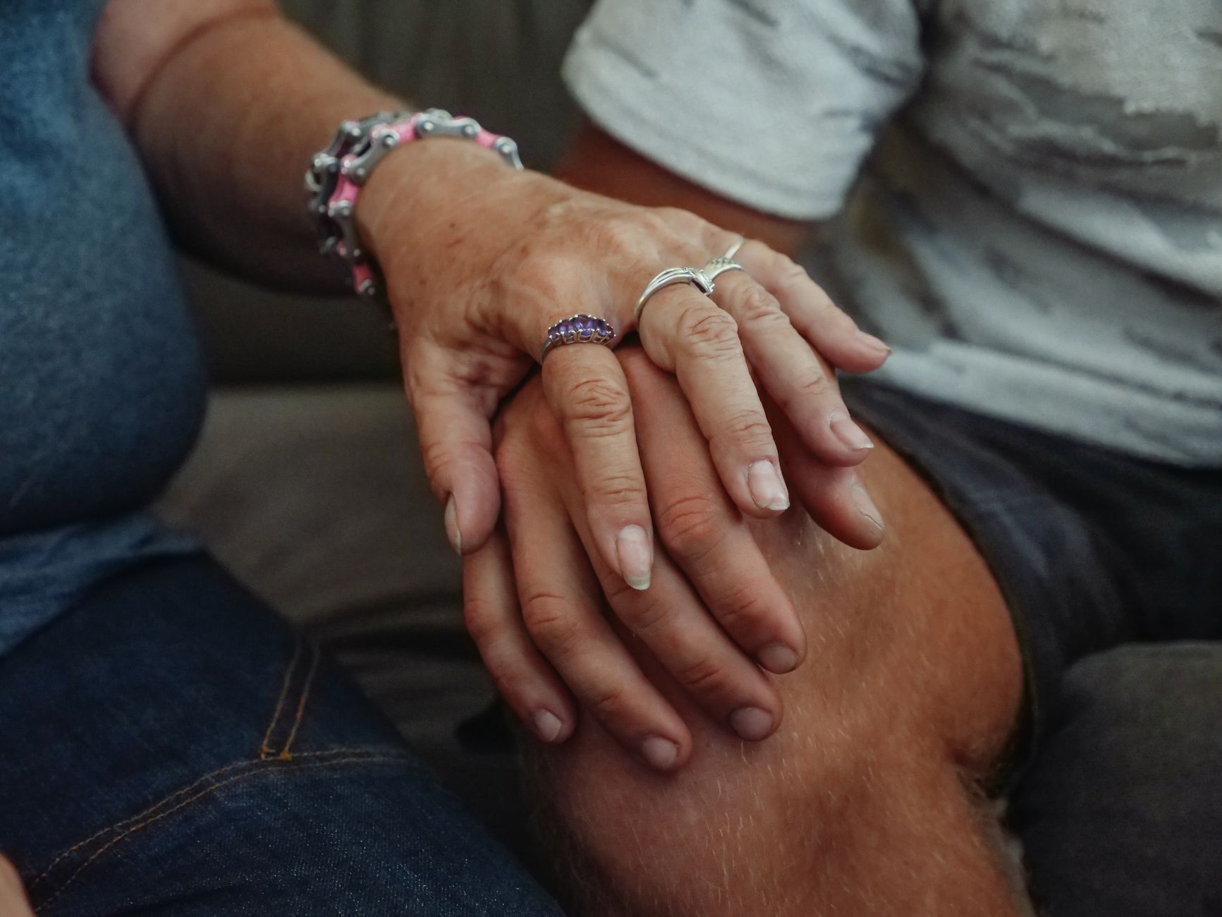 Couple holding hands gently after loss