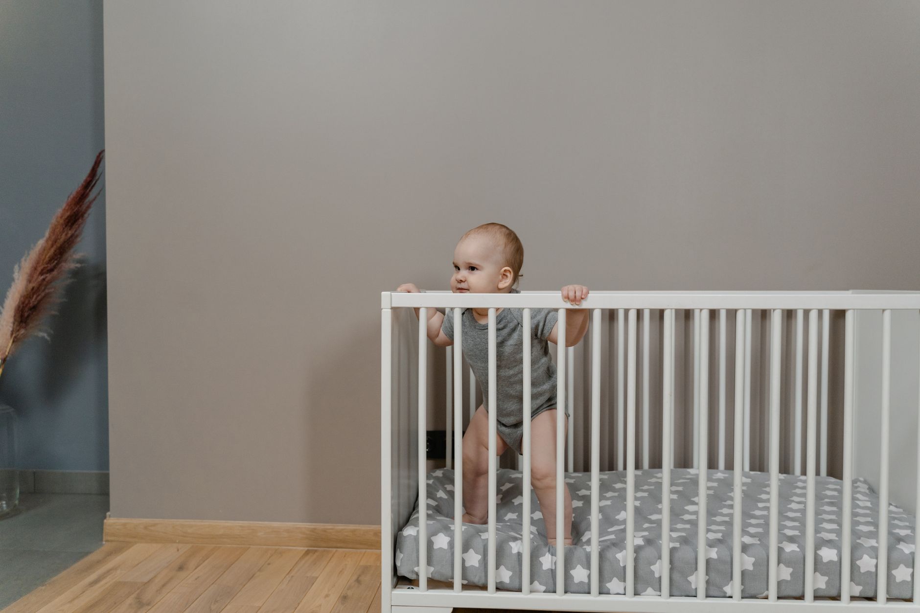 A baby sleeping peacefully in a crib with a fitted sheet, no loose bedding.
