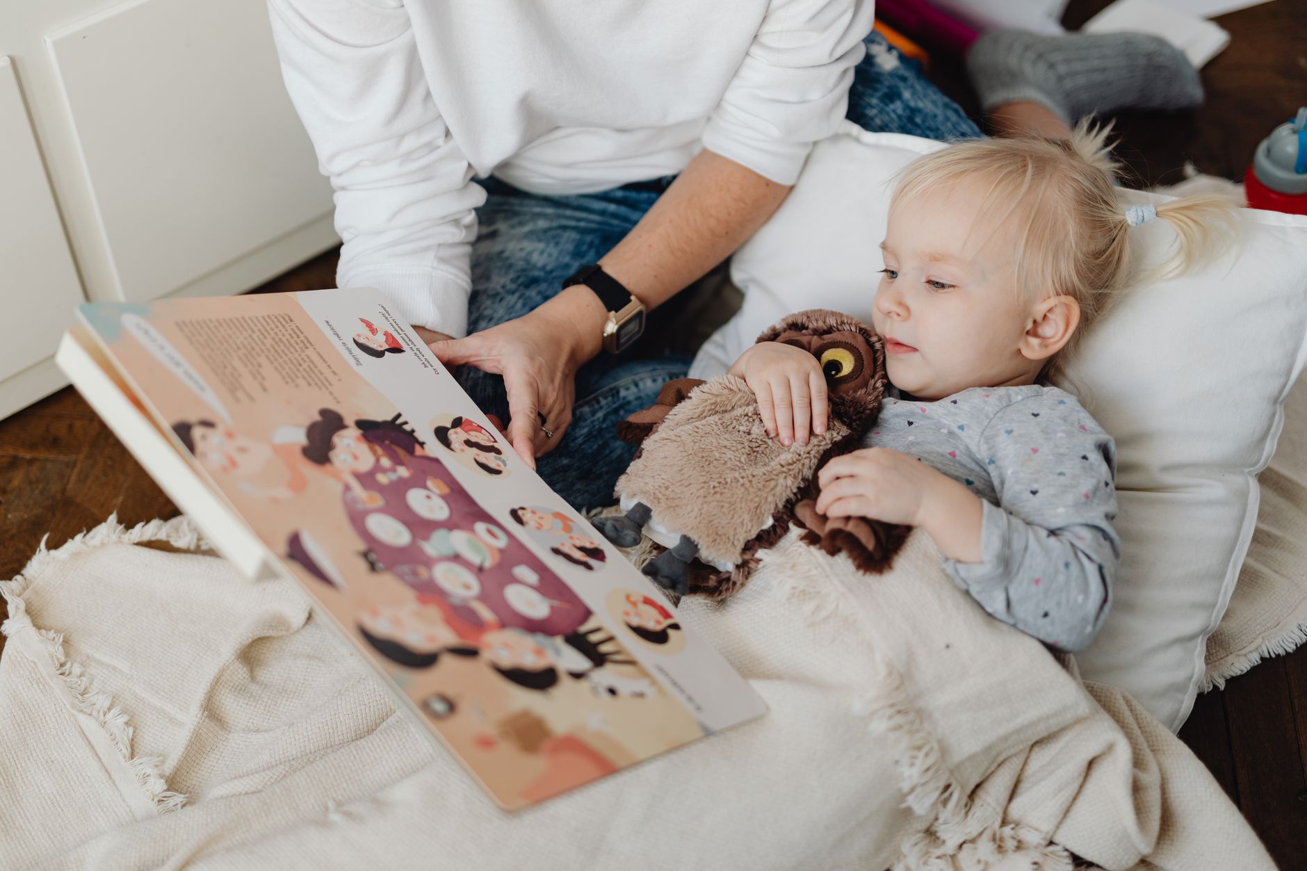 Parent reading bedtime story to toddler