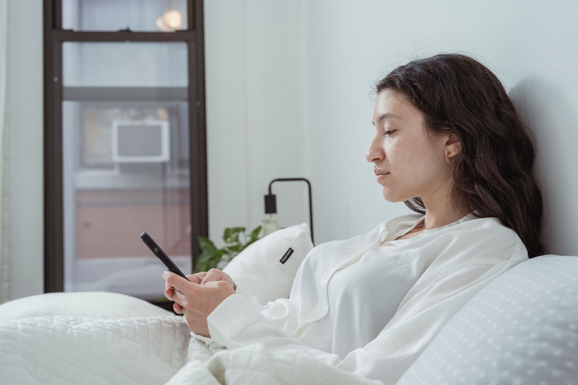 Pregnant woman using wedge and knee pillows for tailbone comfort