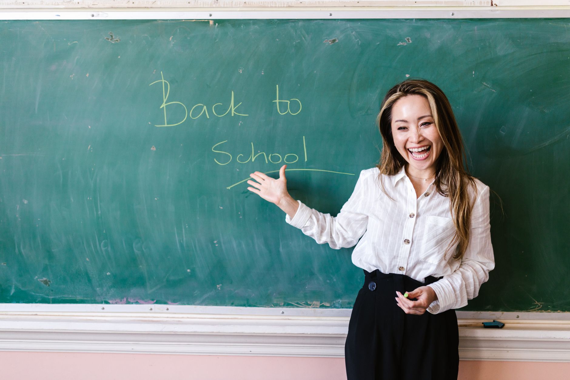 Teacher holding newborn in classroom