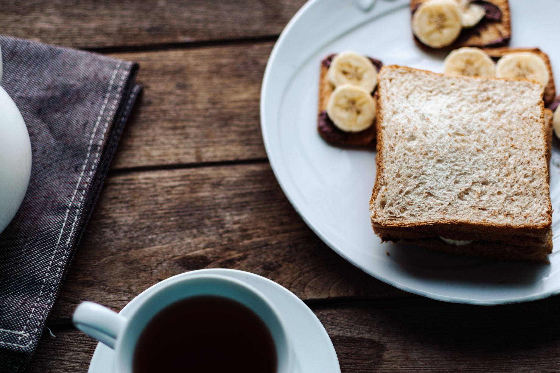 A small plate with toddler-friendly bedtime snacks: whole‑grain crackers, sliced banana, and a cup of warm milk with a cinnamon stick