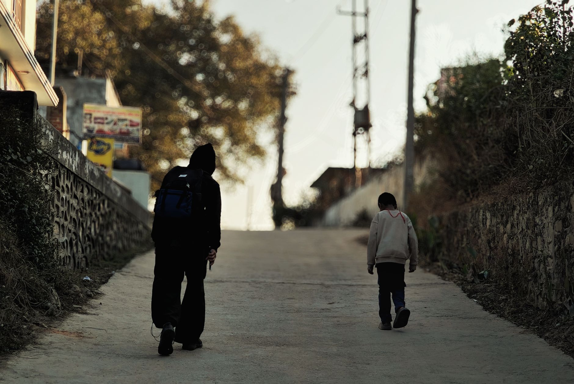 A mother holding hands with her young child, walking away from the camera, symbolizing moving forward.