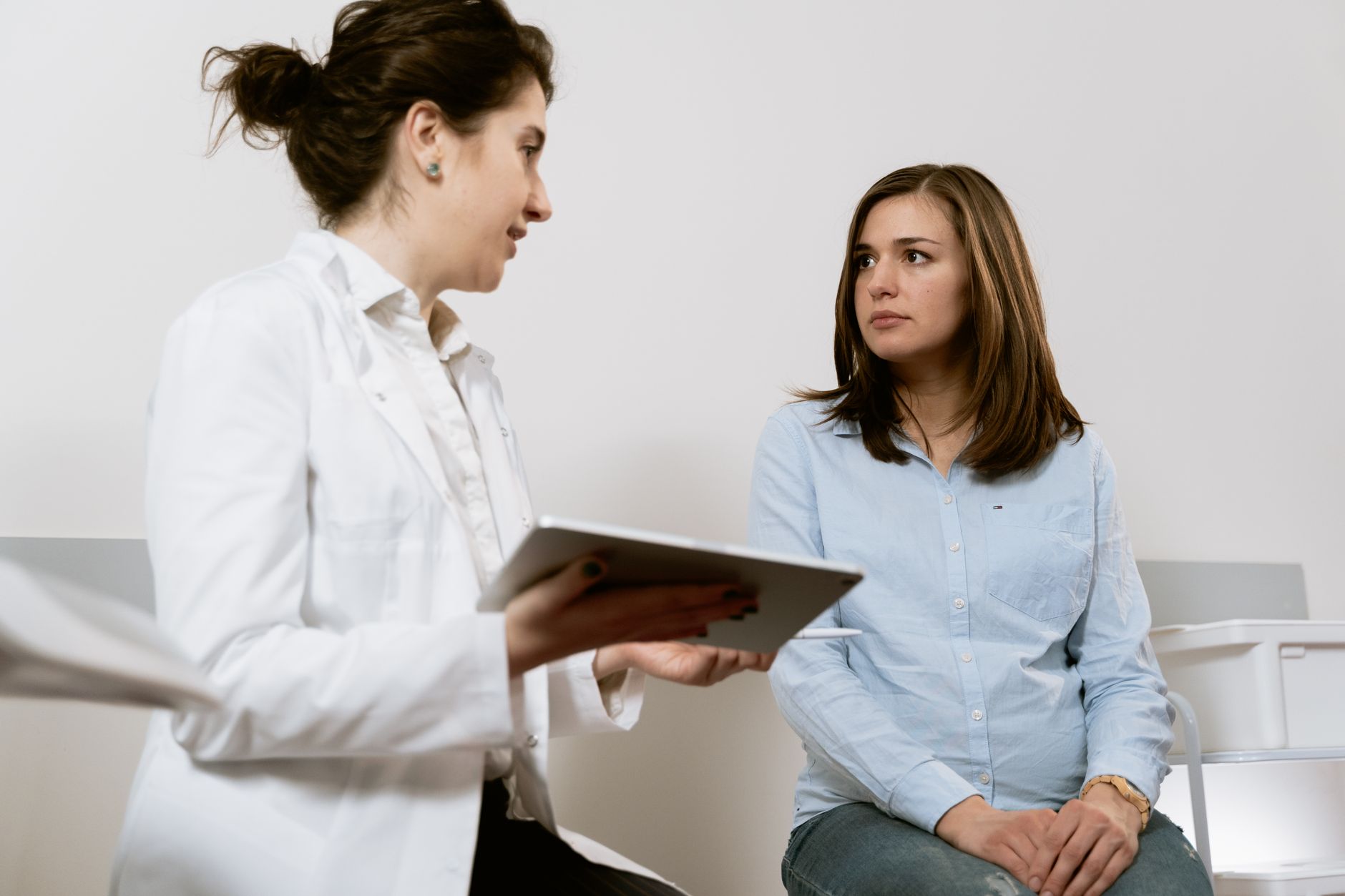 Two parents holding hands during a hospital tour, reviewing birth plan options with a midwife