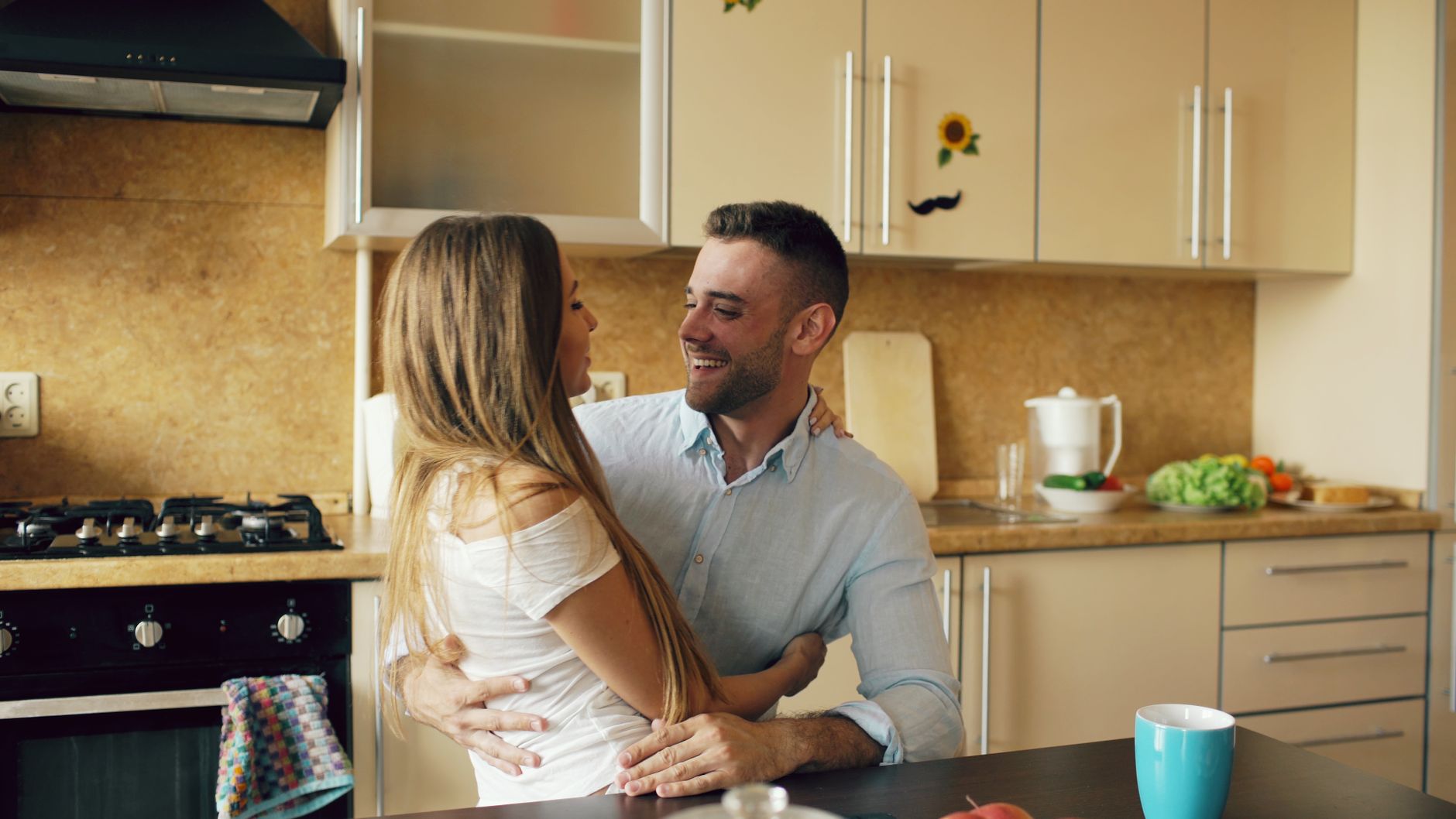 Pregnant woman sitting at a kitchen table reviewing a printed ultrasound report with a partner, soft natural light, calm atmosphere