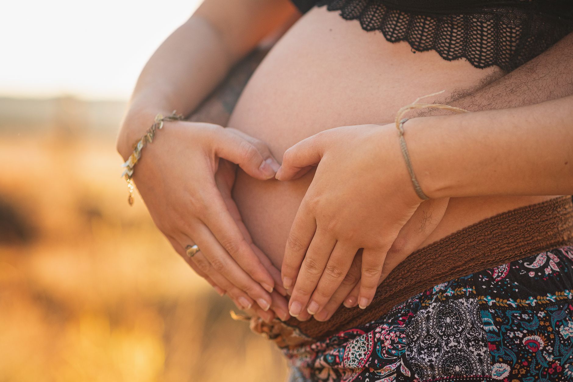 Pregnant woman's hands cradling belly