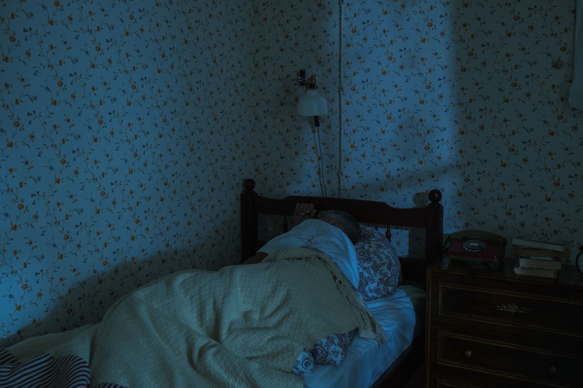 A cozy bedroom scene with a pregnant person using a low‑weight weighted sleep sack, a nightstand lamp, and a calming lavender scent diffuser, illustrating a safe bedtime routine.