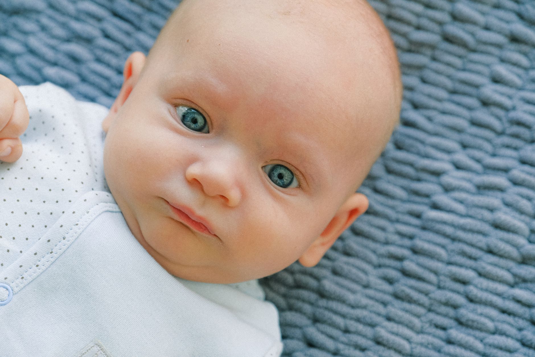 Side‑by‑side comparison of newborn milia (white smooth spots) and baby acne (red papules) on a baby's cheek, soft lighting, clean nursery background