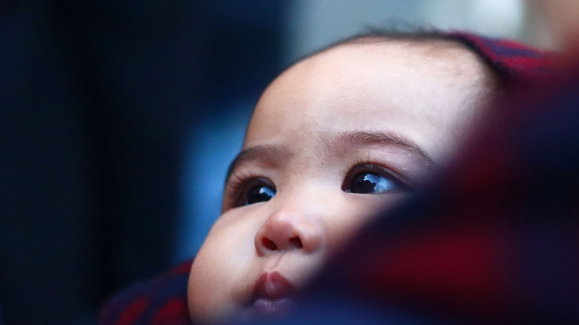 Side-by-side photos of a baby's eyes at birth (blue) and at 12 months (green)