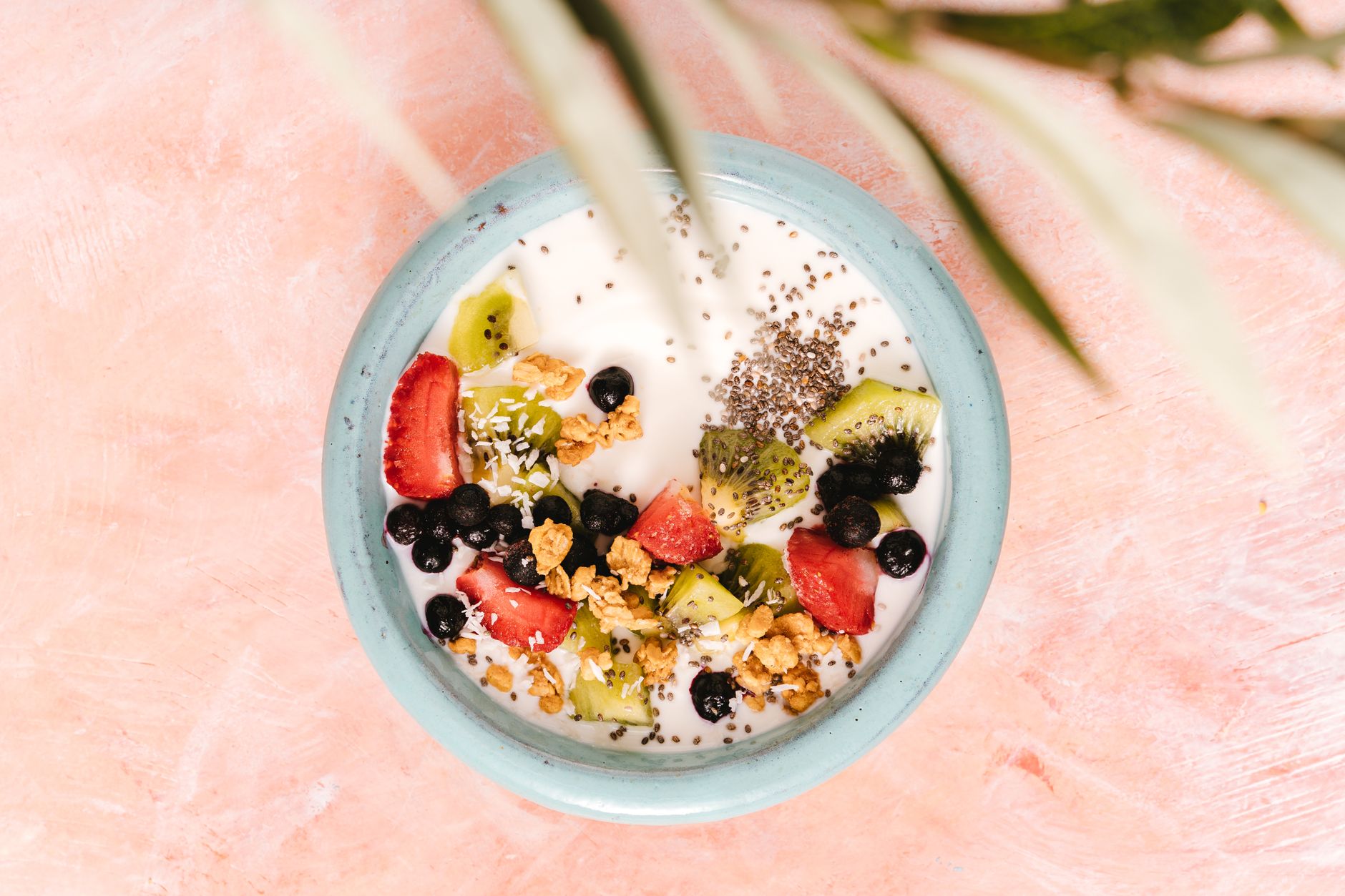 Close‑up of a bowl of mixed berries, chia seeds, and Greek yogurt topped with honey, bright kitchen light, inviting breakfast for a pregnant woman