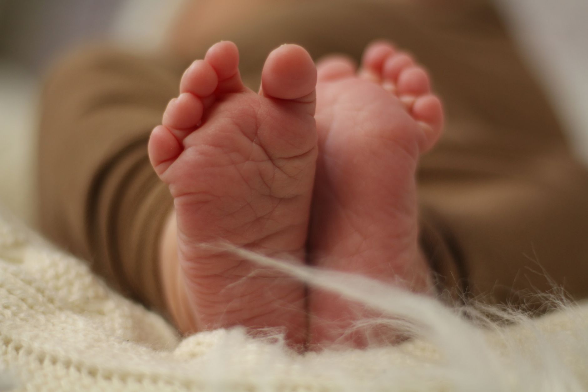 A parent gently rocking a newborn in a cozy, softly lit nursery, emphasizing responsive parenting and bonding