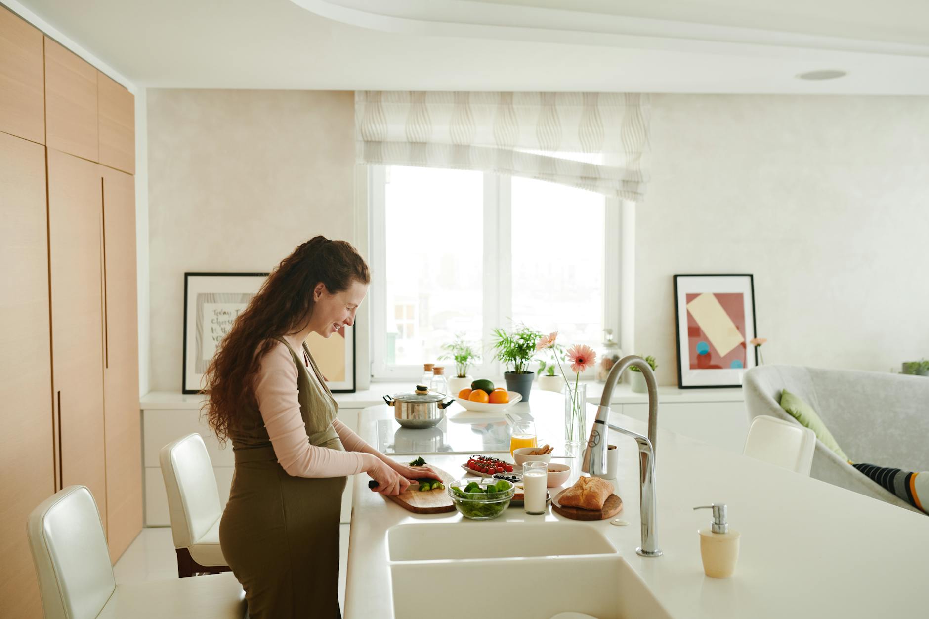 A pregnant woman holding a plate of fruits and vegetables, with a happy expression