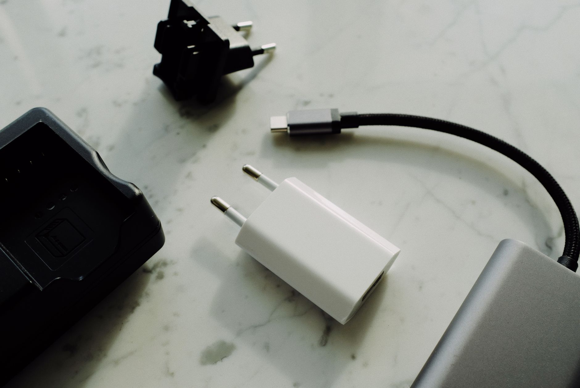 A tidy hospital bag open on a bedside table, showing a robe, slippers, snack container, and a small power bank, captured in soft natural light