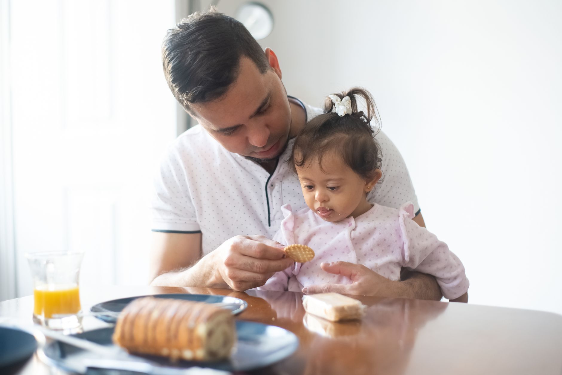 Toddler with a cup of milk and crackers