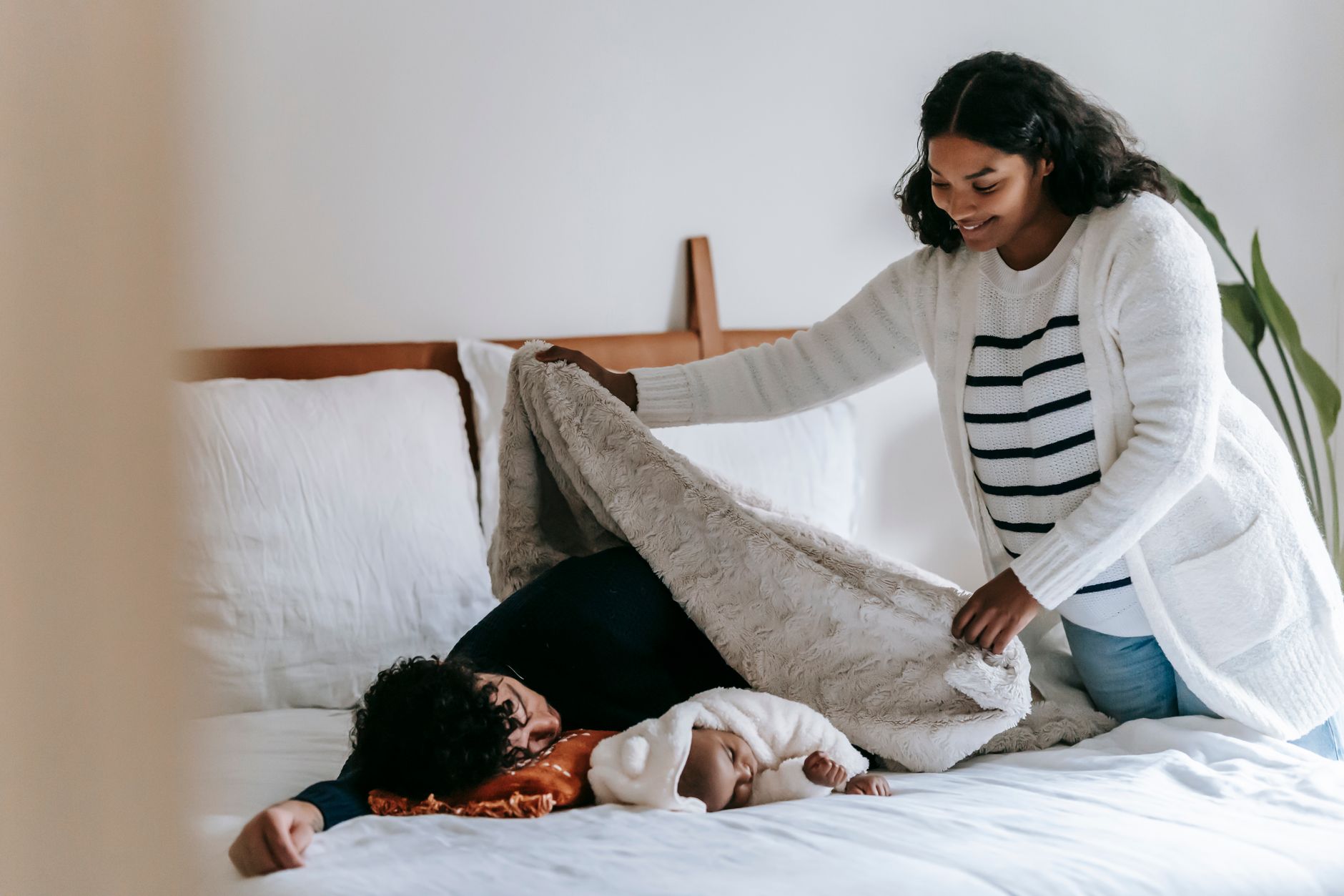 Parent tucking blanket under mattress