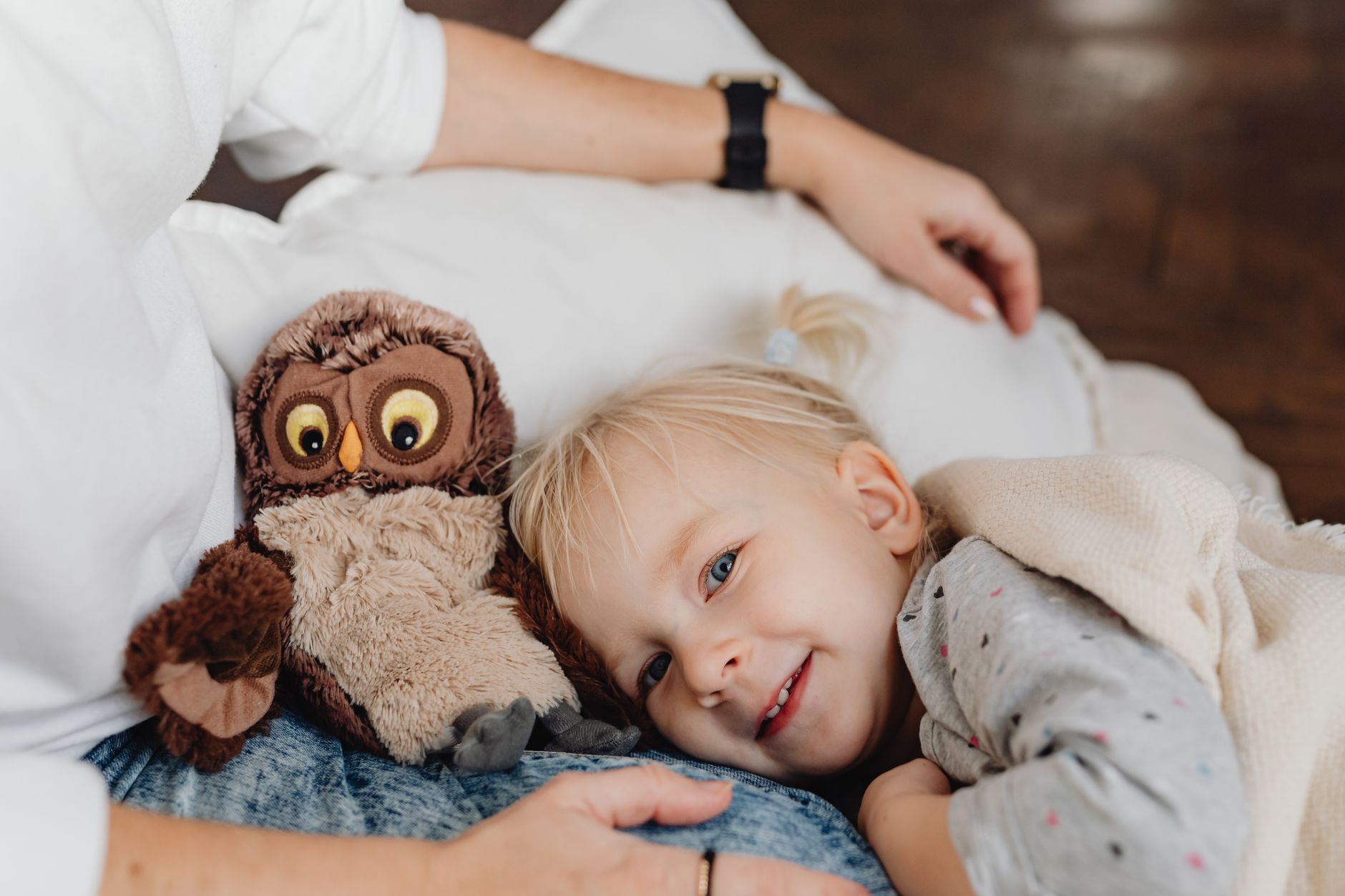 A toddler happily hugging a small, soft stuffed animal during playtime