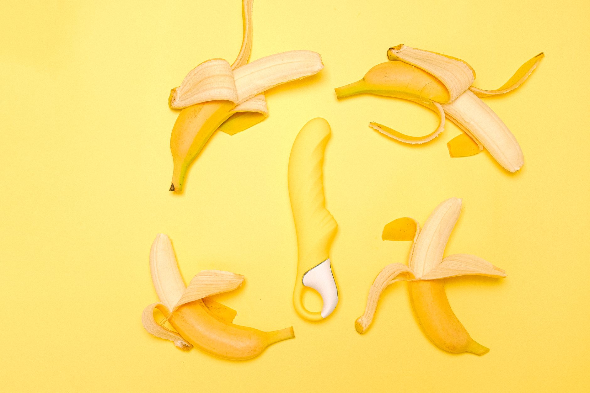 A colorful flat‑lay of teething toys, a chilled silicone ring, a banana slice, and a soft cloth, bright morning light on a wooden board