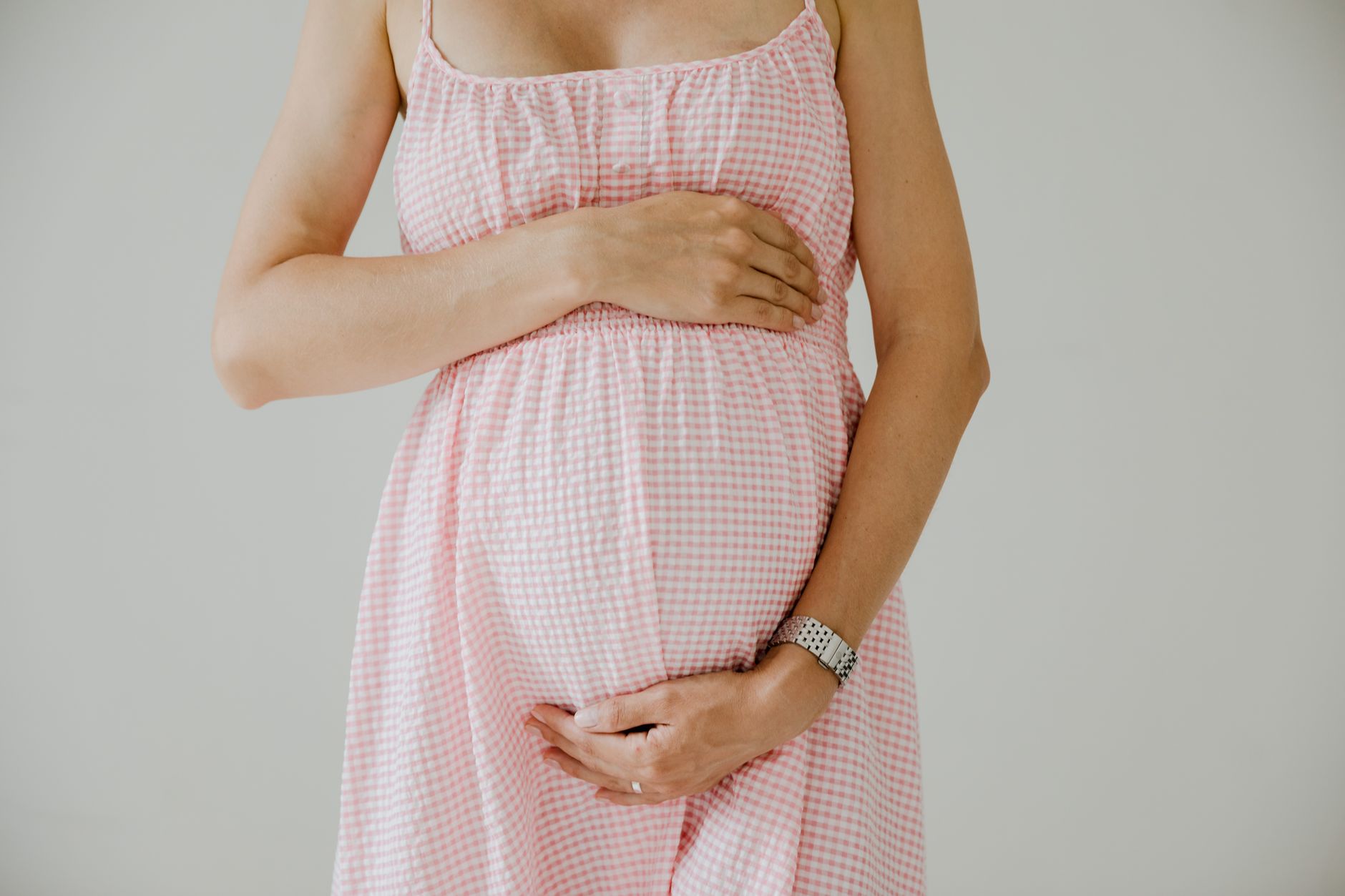 Illustration of a pregnant belly at each trimester, showing gradual expansion and skin stretching, soft pastel colors, clean graphic style