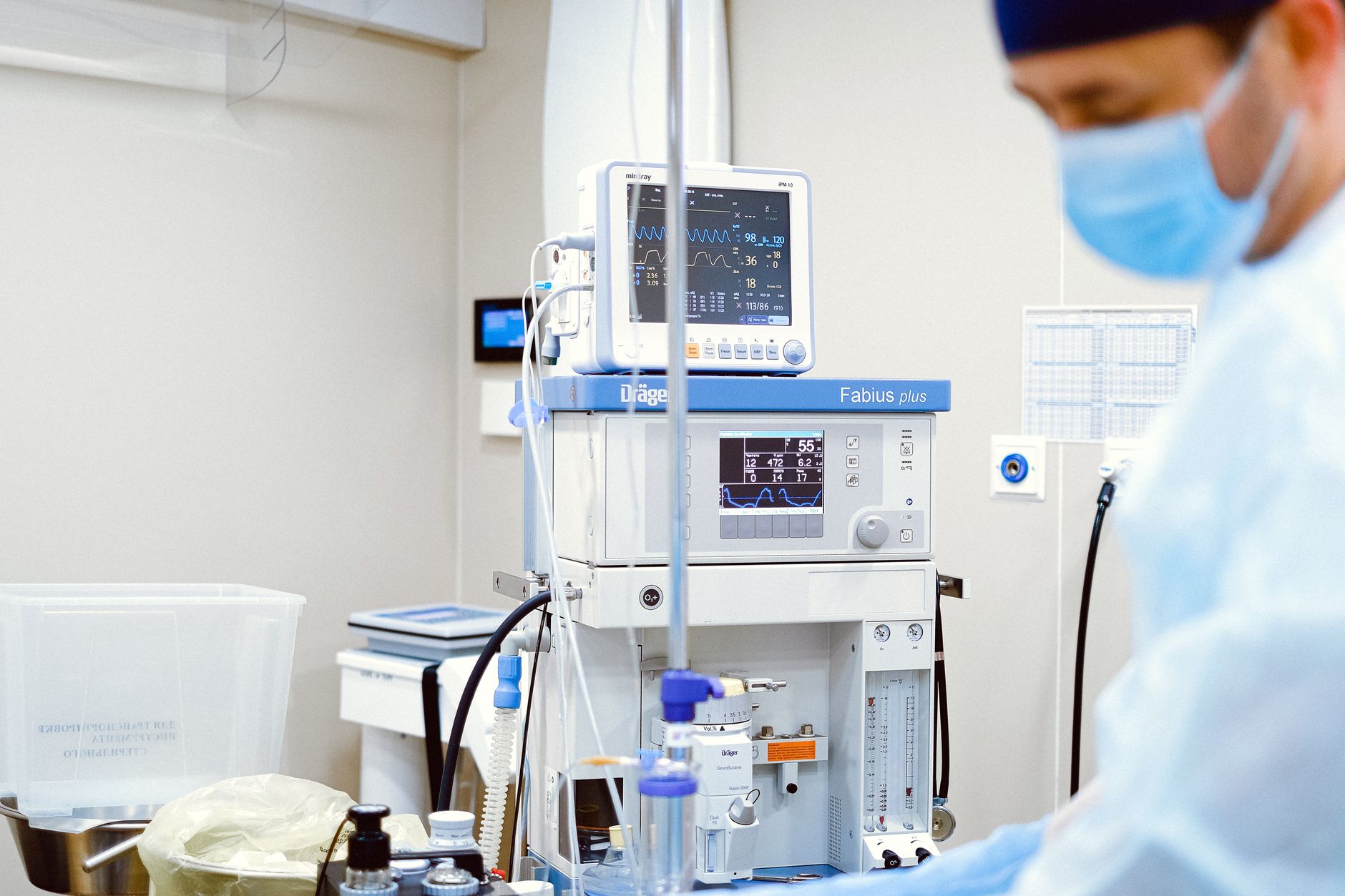A preterm infant in a neonatal incubator, gestational week markers displayed on a monitor, soft diffused light