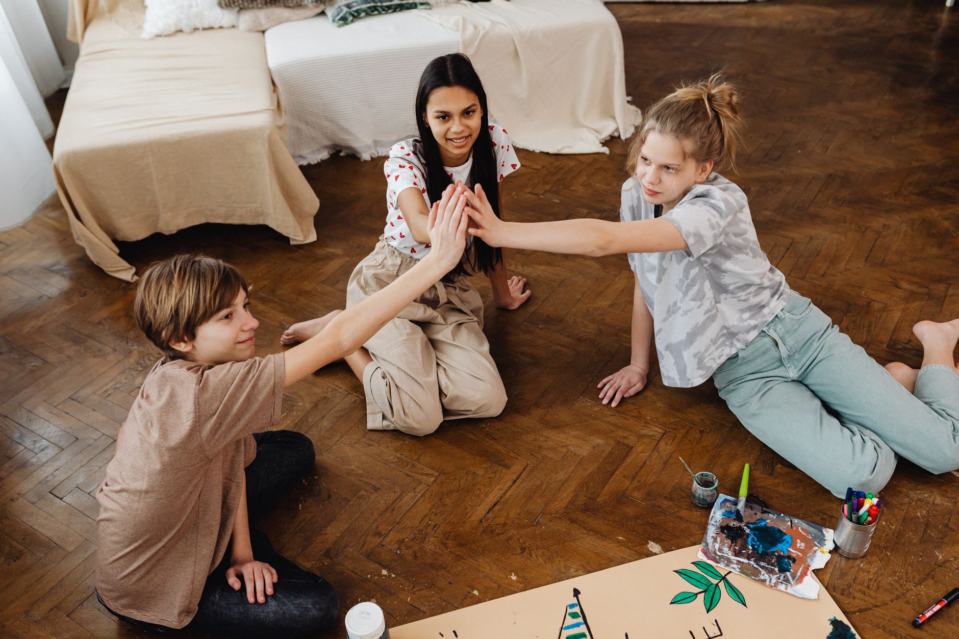 A couple sitting on the floor with their toddler, working together on a jigsaw puzzle