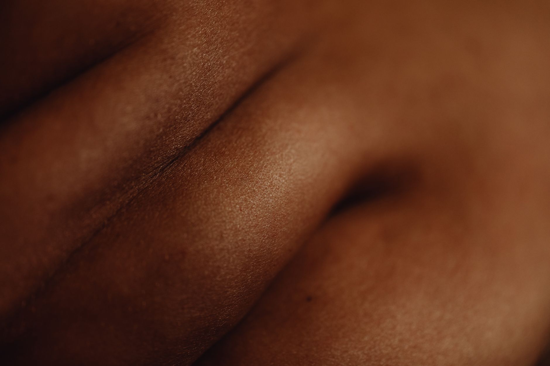 A close‑up of a newborn’s cheek showing a gentle yellow tint, with a soft blanket background, indicating mild jaundice